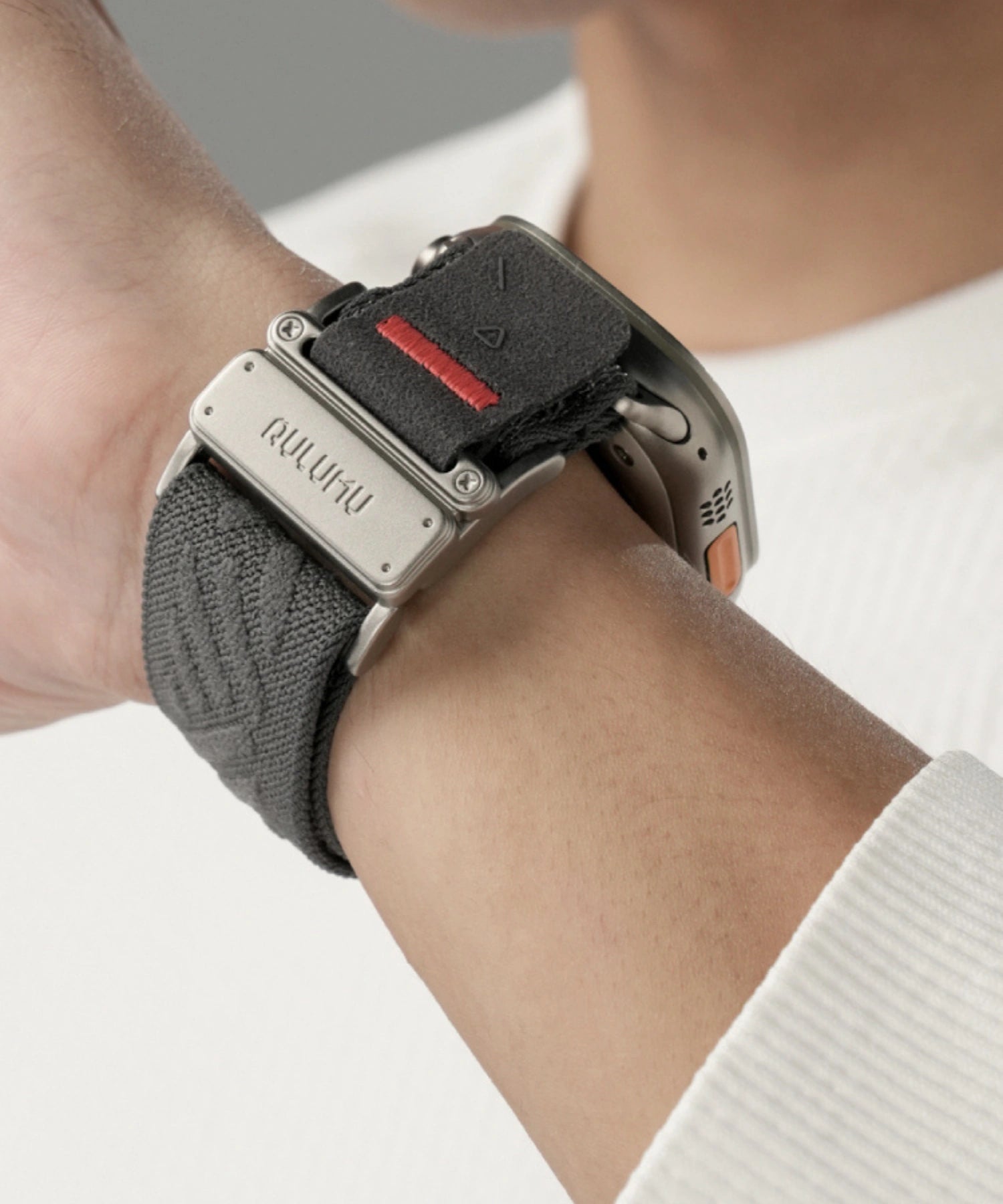 Close-up of an Apple Watch Ultra on wrist with an AULUMU nylon sport band, featuring a metal buckle and red accent stitch